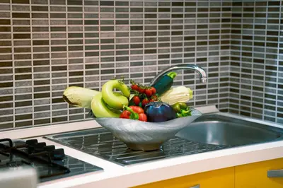 a bowl of fruits and vegetables sitting on a sink at Appartamenti Bellini in Castellammare del Golfo