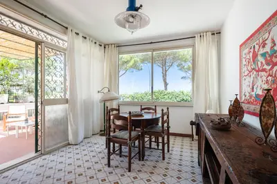 a dining room with a table and chairs and a window at Le Casette all'Addaura by Domus Sicily in Mondello