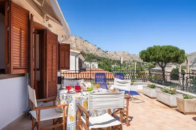 a table and chairs on the balcony of a house at Le Casette all'Addaura by Domus Sicily in Mondello