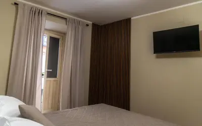 a bedroom with a bed and a television on a wall at Prestige in Palermo