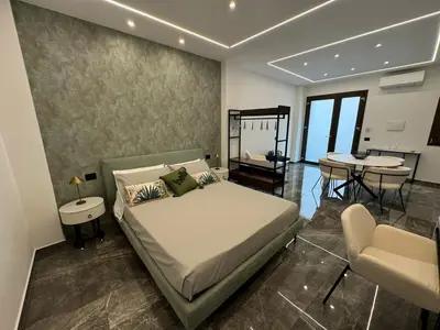 a bedroom with a bed and a table and chairs at GRA' Suite Deluxe in Terrasini