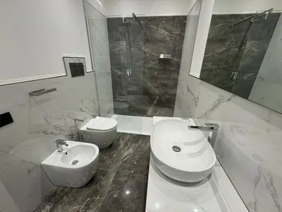 a bathroom with a toilet and a sink and a shower at GRA' Suite Deluxe in Terrasini
