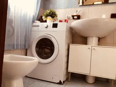 a bathroom with a washing machine and a sink at Casa ivan in Palermo