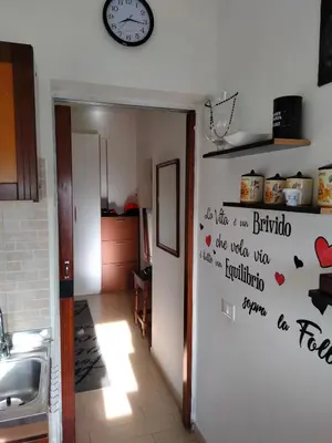 a kitchen with a wall with a clock on the wall at Casa ivan in Palermo