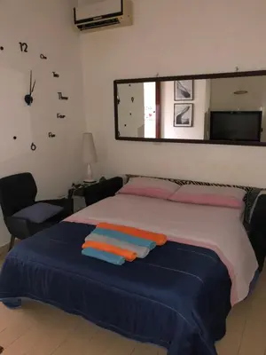 a bedroom with a bed with a mirror and a chair at Casa ivan in Palermo