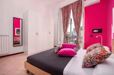 a bedroom with pink walls and a bed with pink pillows at Vista San Domenico in Palermo