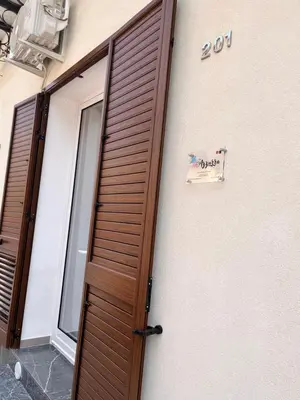 a wooden door to a building with a sign on it at Azzurra in Terrasini