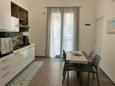 a kitchen with a table and chairs and a kitchen with a window at Azzurra in Terrasini