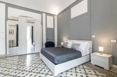 a bedroom with a king sized bed and a mirror at GuestHost - La Dimora dei Mille - Roomy Apartment with Terrace in Palermo