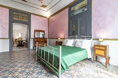 a bedroom with a bed in a room with pink walls at GuestHost - La Dimora dei Mille - Roomy Apartment with Terrace in Palermo