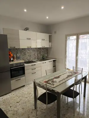 a kitchen with a table and two chairs and a stove at Home For You in Carini