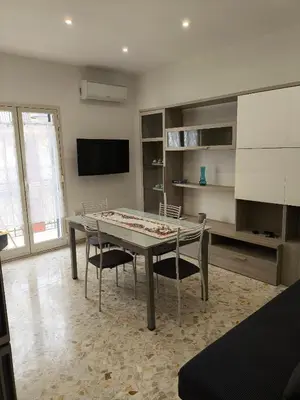 a dining room with a table and chairs and a television at Home For You in Carini