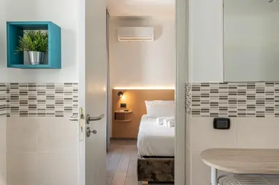 a small bedroom with a bed and a table at Naos Home - Alle Spalle del Teatro Massimo in Palermo
