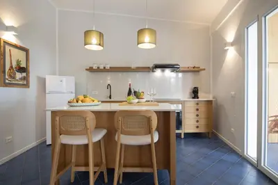 a kitchen with a island with two stools at Villa Makar Seaview in Macari