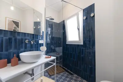 a bathroom with a blue tiled wall at Villa Makar Seaview in Macari