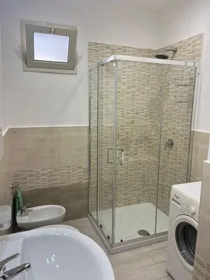 a bathroom with a shower and a sink and a washing machine at La casa di Gabri in Palermo