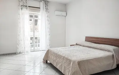 a white bedroom with a bed and a window at Lovely Apartment In Casteldaccia in Casteldaccia