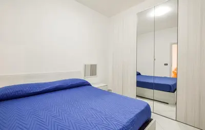 a bedroom with a blue bed and a mirror at Lovely Apartment In Casteldaccia in Casteldaccia