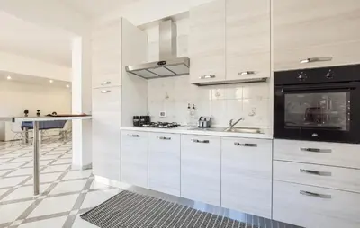 a kitchen with white cabinets and a stove top oven at Lovely Apartment In Casteldaccia in Casteldaccia