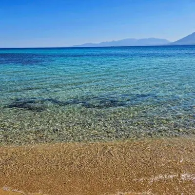a beach with the clear blue water and rocks at Le Case di Ciccine' in Bagheria