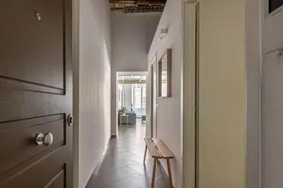 a hallway with a wooden table and a chair at MetaM Apartment in the City Center by Wonderful Italy in Palermo