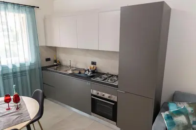 a kitchen with a stove and a sink and a table at Bagheria Home in Bagheria