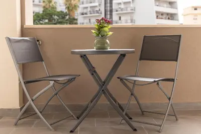 two chairs and a table with a vase of flowers on it at Bagheria Home in Bagheria