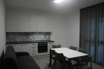 a kitchen with a table and chairs and a kitchen with white cabinets at villa grecale in Castellammare del Golfo