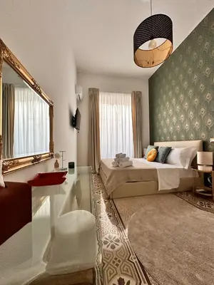 a bedroom with a large bed and a mirror at Il Sipario Luxury Apartments in Palermo