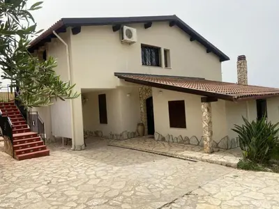 a white house with a staircase in front of it at La villa di Turi in Castellammare del Golfo