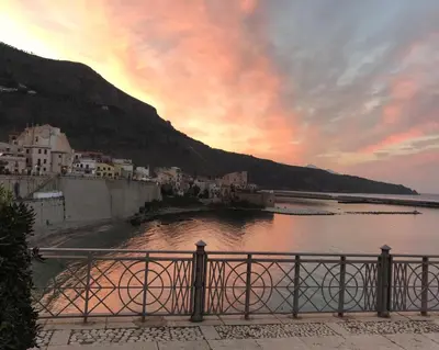 a sunset over a body of water with buildings at La villa di Turi in Castellammare del Golfo