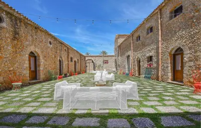 an outdoor courtyard with white tables and chairs at Cozy Home In Partinico With Wifi in Partinico