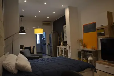 a bedroom with a blue bed and a living room at Little Loft 39 in Palermo