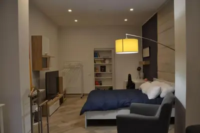 a bedroom with a bed and a couch and a tv at Little Loft 39 in Palermo