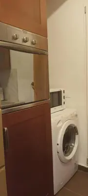 a kitchen with a washing machine and a microwave at Home Sweet Home in Palermo