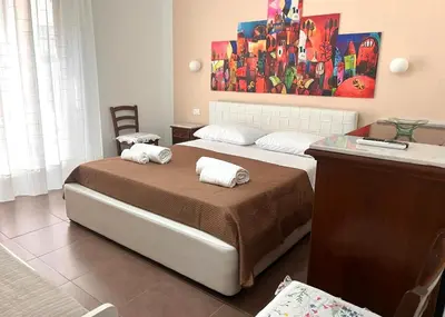 a bedroom with two beds and a painting on the wall at Home Sweet Home in Palermo