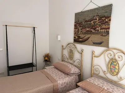 a bedroom with two beds and a painting on the wall at Home Sweet Home in Palermo