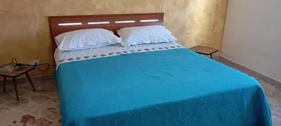 a bedroom with a large bed with blue pillows at Apartament di Nick Central Station No ZTL in Palermo