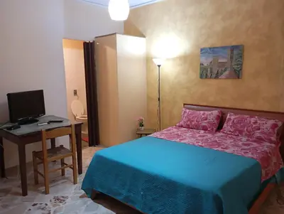 a bed with two pillows and a chair in a bedroom at Apartament di Nick Central Station No ZTL in Palermo