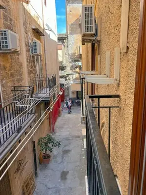 an alley with people walking down a street at Ai Pupi Siciliani in Palermo