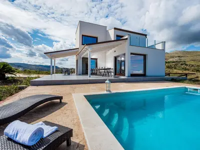 a villa with a swimming pool in front of a house at Villa Rocchi Livreri by Interhome in Scopello