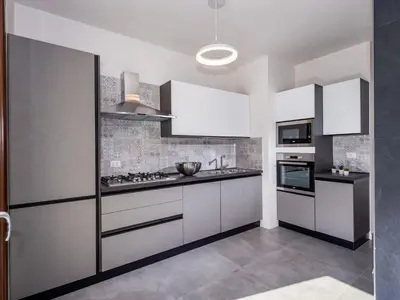 a kitchen with white cabinets and a stove at Villa Rocchi Livreri by Interhome in Scopello