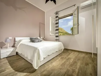 a white bedroom with a bed and a window at Villa Mari e Monti by Interhome in Castellammare del Golfo