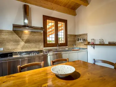 a kitchen with a wooden table with a bowl on it at Villa Le Muse by Interhome in Scopello