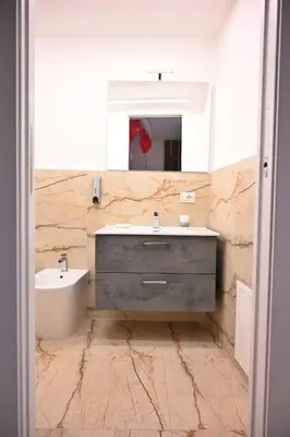 a bathroom with a sink and a mirror at Raquel suite and SPA in Palermo