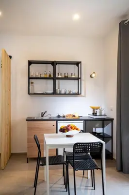 a kitchen with a white table and chairs and a counter at MamErì central rooms in Castellammare del Golfo