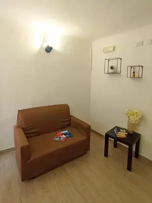 a living room with a brown couch and a table at Mille Memories Apartment in Palermo