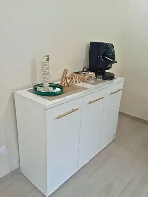 a white cabinet with a microwave on top of it at Mille Memories Apartment in Palermo