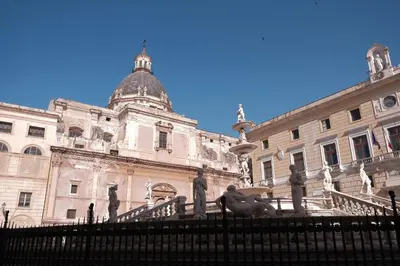 a building with a statue in front of it at Palazzo Giglio suite in Palermo