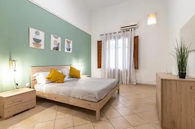 a bedroom with a bed with yellow pillows on it at GuestHost - Your Home at the Cathedral - Palermo Cozy Flat in Palermo